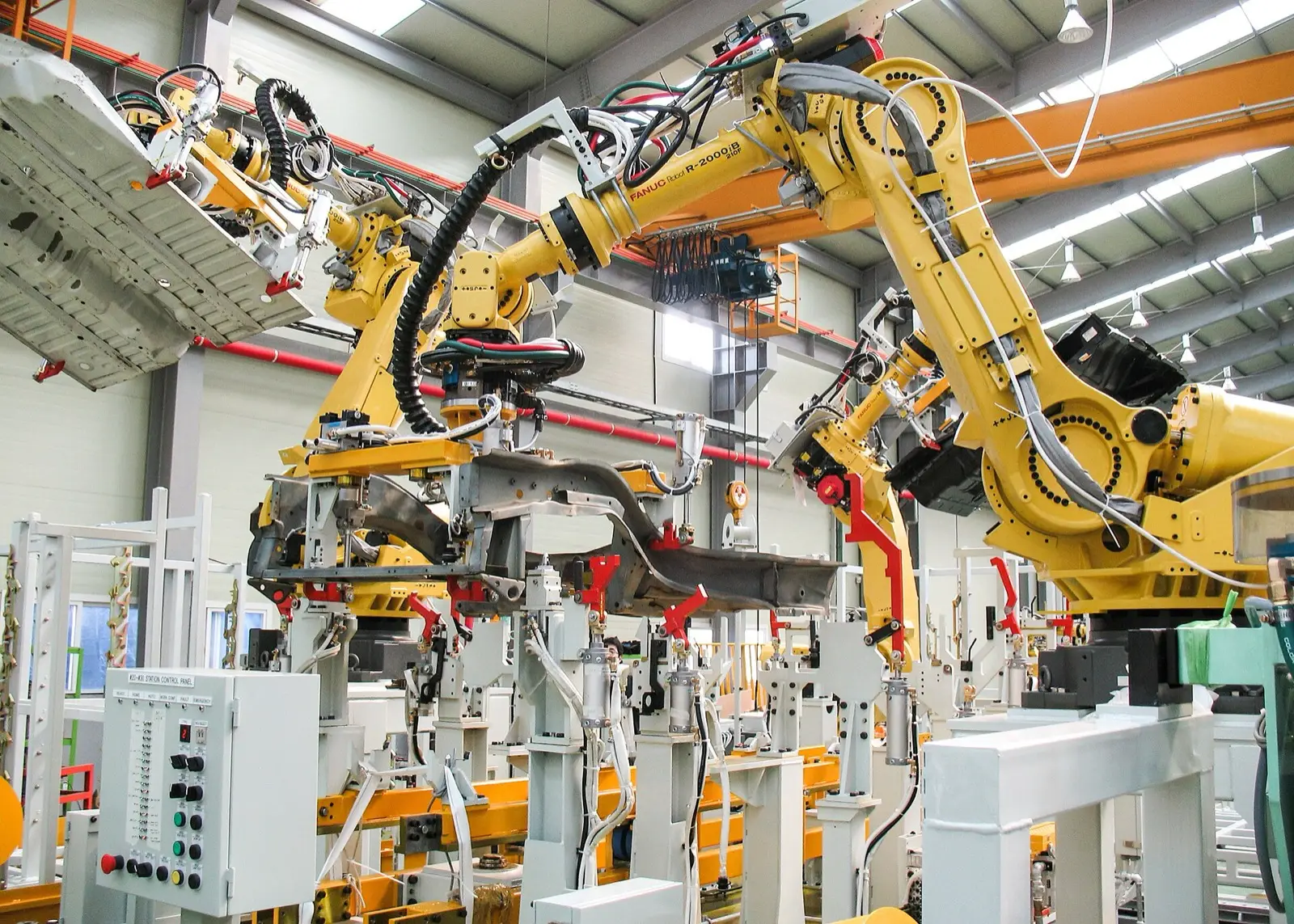 Braços robóticos em linha de produção industrial