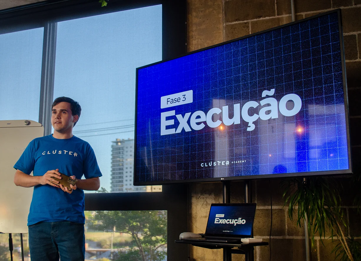Integrante da Cluster conduzindo uma apresentação da Cluster Academy no espaço da empresa
