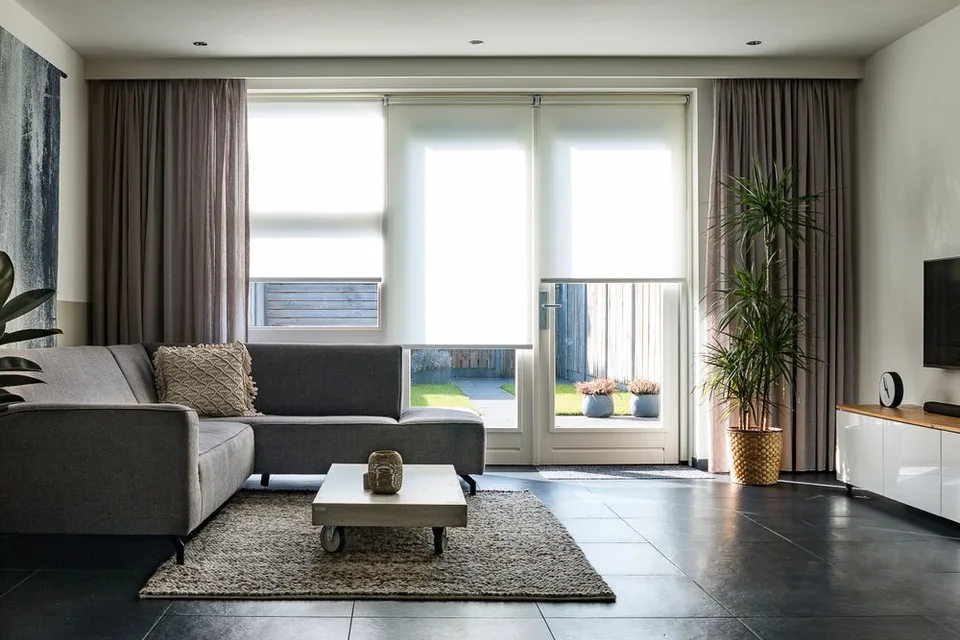 Sala de apartamento com sofá, iluminação natural e acesso ao jardim